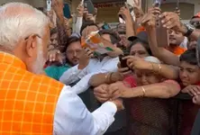 Woman ties rakhi to PM Modi as huge crowd gathers outside polling booth in Ahmedabad